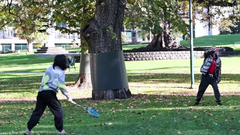 a girl and her grandpa enjoy badminton outdoors