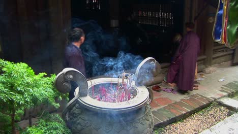 monks gather as incense scents the air at a vietnamese temple