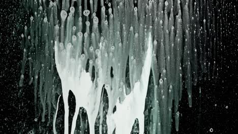 white soap foam dripping on a black surface