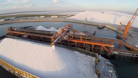 Aerial-shot-of-a-large-barge-being-filled-with-salt-in-the-salt-flats-by-solar-evaporation-in-Guerrero-Negro,-Ojo-de-Liebre-lagoon,-Biosphere-Reserve-of-El-Vizcaino,-Baja-California-Sur