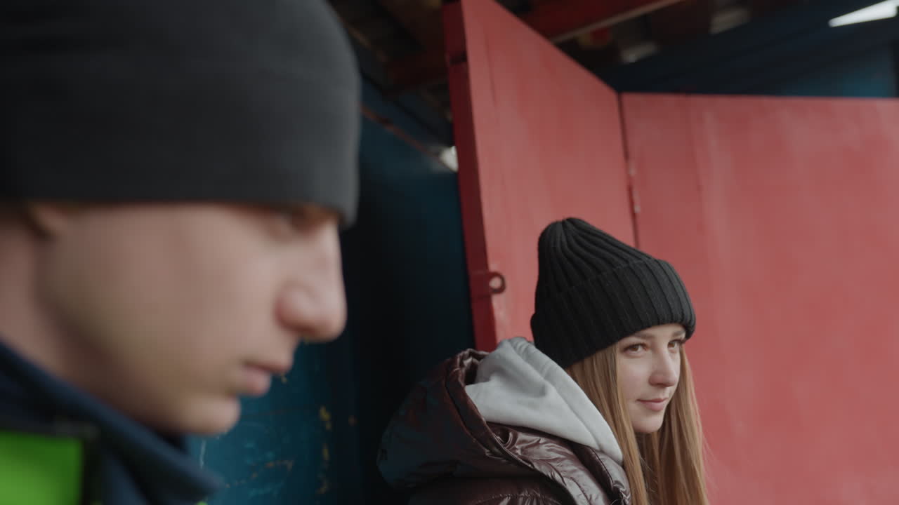 Молодые игроки обмениваются дружелюбными взглядами, мимолетный кадр непринужденной беседы друзей, неформальная обстановка, спортсмены проявляют дух товарищества в спокойной и располагающей обстановке