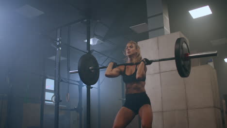 athletic beautiful woman does overhead deadlift with a slow motion: barbell in the gym. gorgeous female professional bodybuilder workout weight lift exercises in the authentic fit training facility