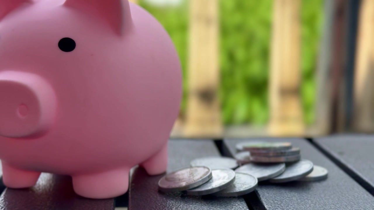 Money saving concept with pink piggy bank and coins, ideal for finance, banking, economy, investment, and cash management themes.