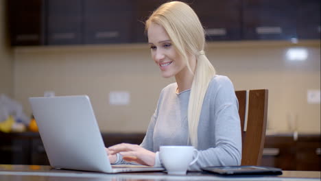 una mujer de negocios sonriente escribiendo en su portátil.