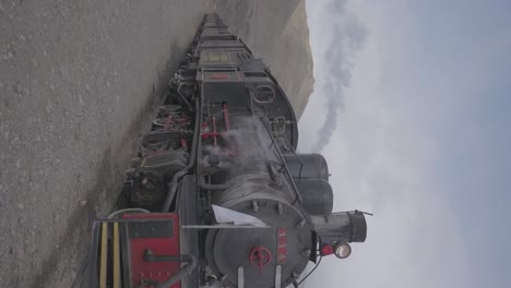 una locomotora de vapor vintage en patagonia, argentina con montañas en el fondo