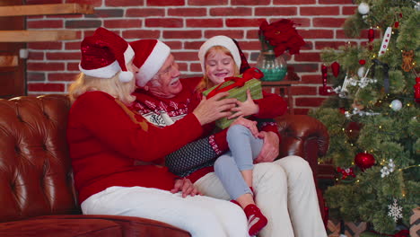 Großvater,-Großmutter-Schenken-Einem-Erstaunten,-Glücklichen-Enkelkind-Zu-Hause-Eine-Weihnachtsgeschenkbox