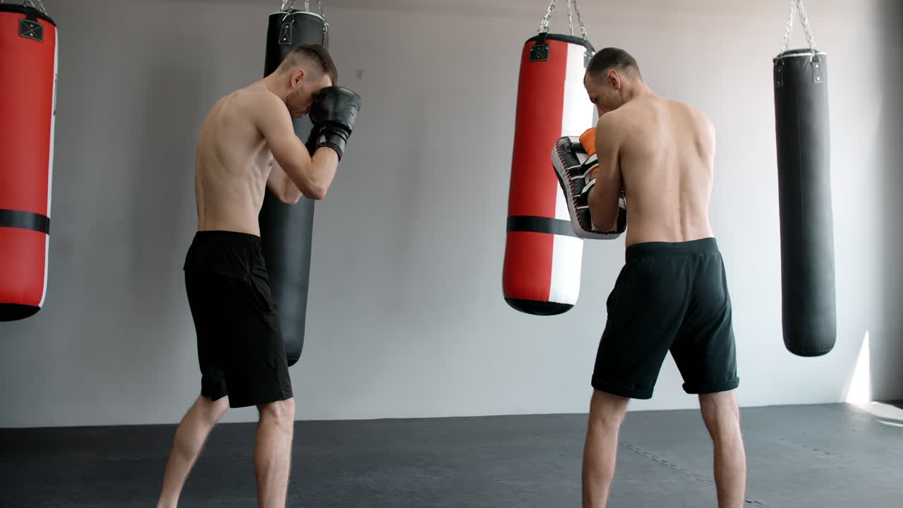 Two men training with punching bags
