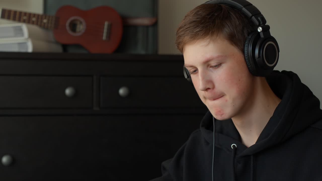 Home studio sound engineer listening to track with headphones