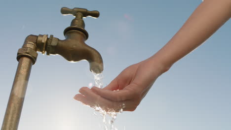 woman washing hand under tap rinsing with freshwater flowing from faucet save water concept