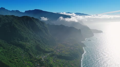 scenic view of the coast at the madeira islands, portugal. aerial perspective on the stunning mountains covered with clouds and dazzled with bright sun.