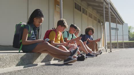 group of kids using smartphones while sitting together