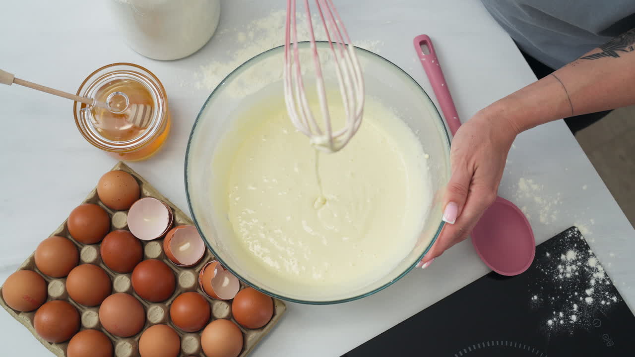 Person stirring a creamy pastry flour dough to make a dessert. Zenithal shot