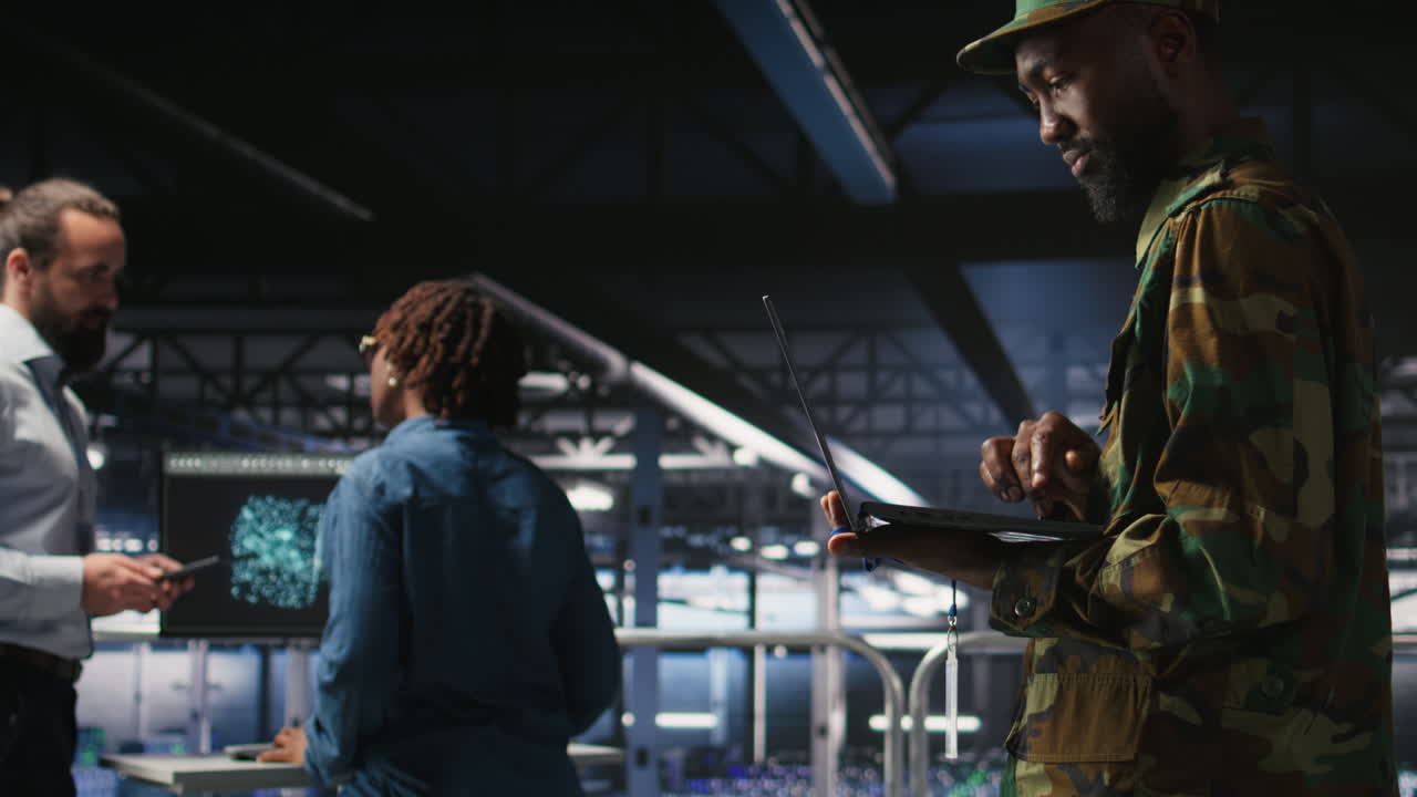 Army technician in command center server room using laptop