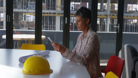 ingeniera femenina usando teléfono móvil en el escritorio 4k