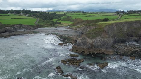 Drone-establishing-shot-of-Ballyvoney-Beach-on-the-Copper-Coast-Drive-Waterford-Ireland-on-a-windy-summer-day