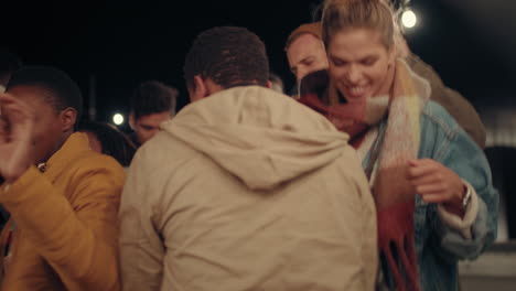 grupo multiétnico de amigos divirtiéndose bailando a la música en la azotea por la noche disfrutando de la fiesta de celebración