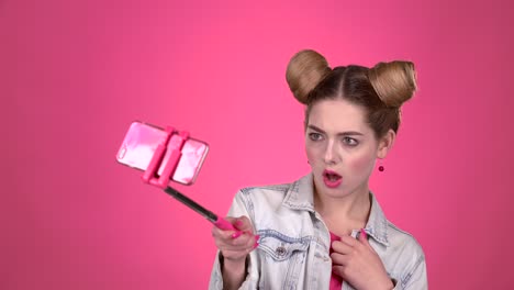 teenager taking a selfie with a pink selfie stick