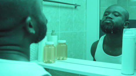 hombre afroamericano enjuagando la boca en el baño
