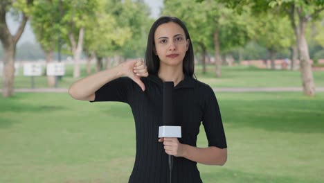 upset indian female news reporter showing thumbs down