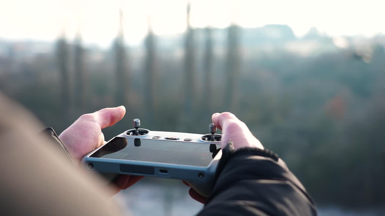 persona que utiliza joysticks de control remoto de drones para probar la sensibilidad de las maniobras de las aeronaves