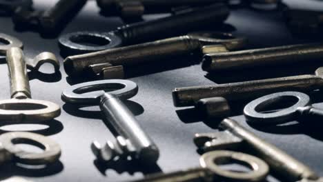 Old keys rotating over black background