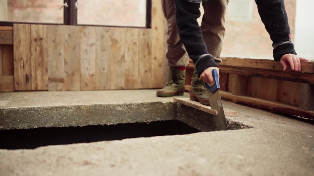 Timelapse Of A Man Cutting Wooden Plank With A Handsaw For The Greenhouse