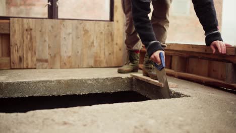 lapso de tiempo de un hombre cortando una tabla de madera con una sierra de mano para el invernadero