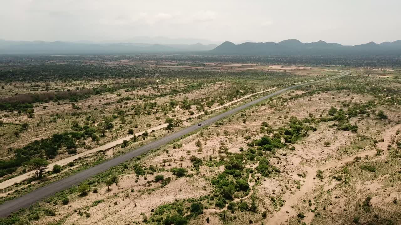 Jeep che attraversa un vasto e pianeggiante paesaggio africano dell'Etiopia