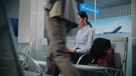 businesswoman working on laptop in airport lounge