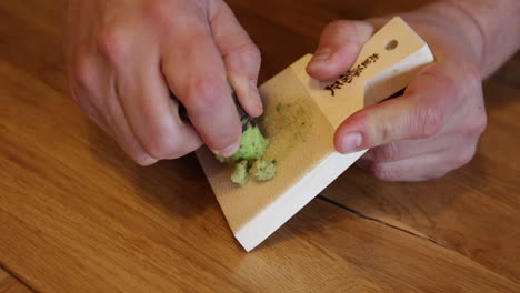 chef de sushi rallar rizoma de wasabi fresco