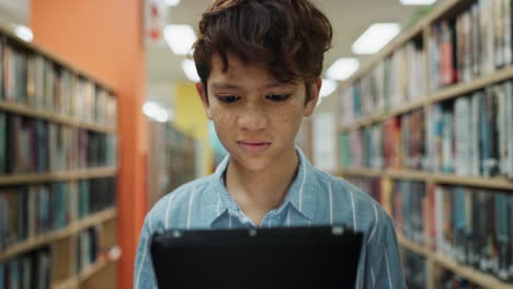 boy using tablet in library