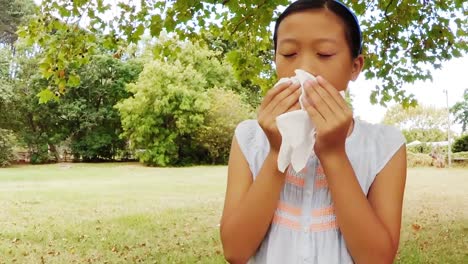 girl blowing her nose with handkerchief while sneezing