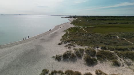 aerial pan of skagen grenen beachside with sand dunes and lighthouse, denmark