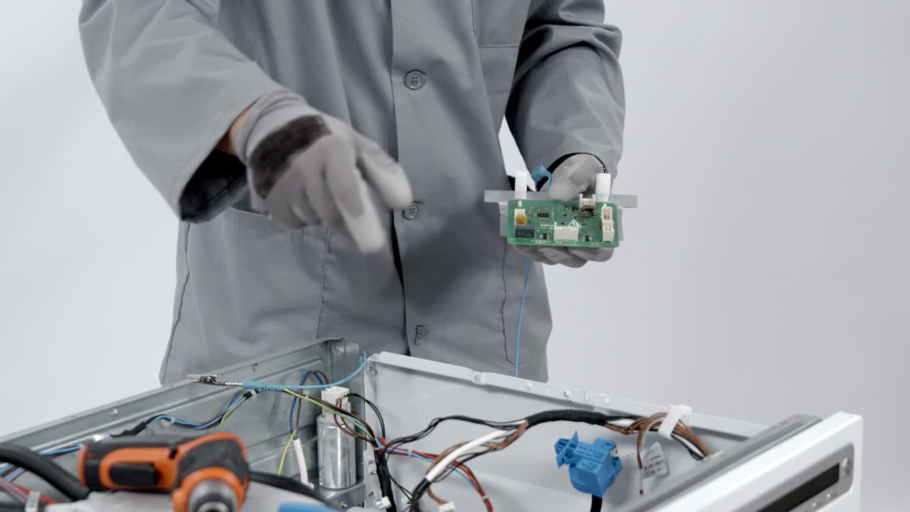 reparador quitando el circuito eléctrico del panel de metal