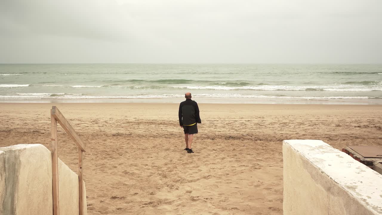 바다 근처에서 고 있는 고령 남자 운동선수