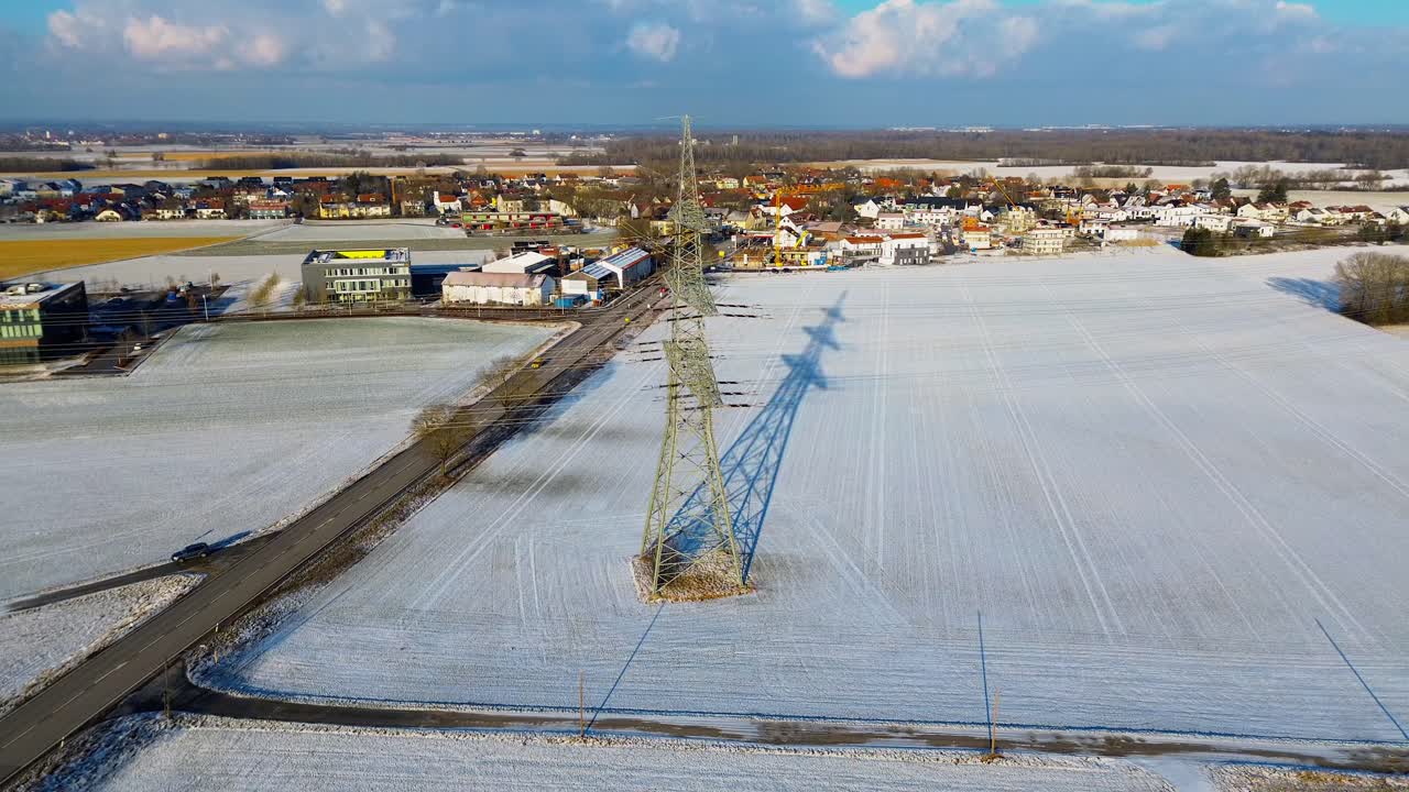 Winter's Grip on a Village with Snow-Covered Fields and Power Lines