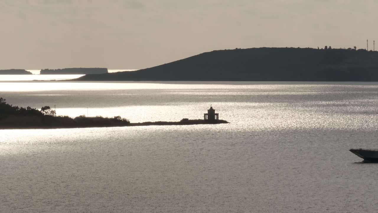 케팔로니아 아르고스톨리의 일몰에 오래된 베네치아 등대 앞을 지나가는 페리 보트