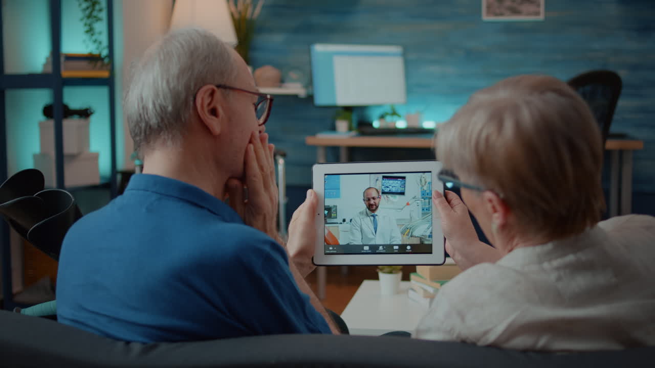 Elderly couple using tablet for telemedicine consultation with doctor