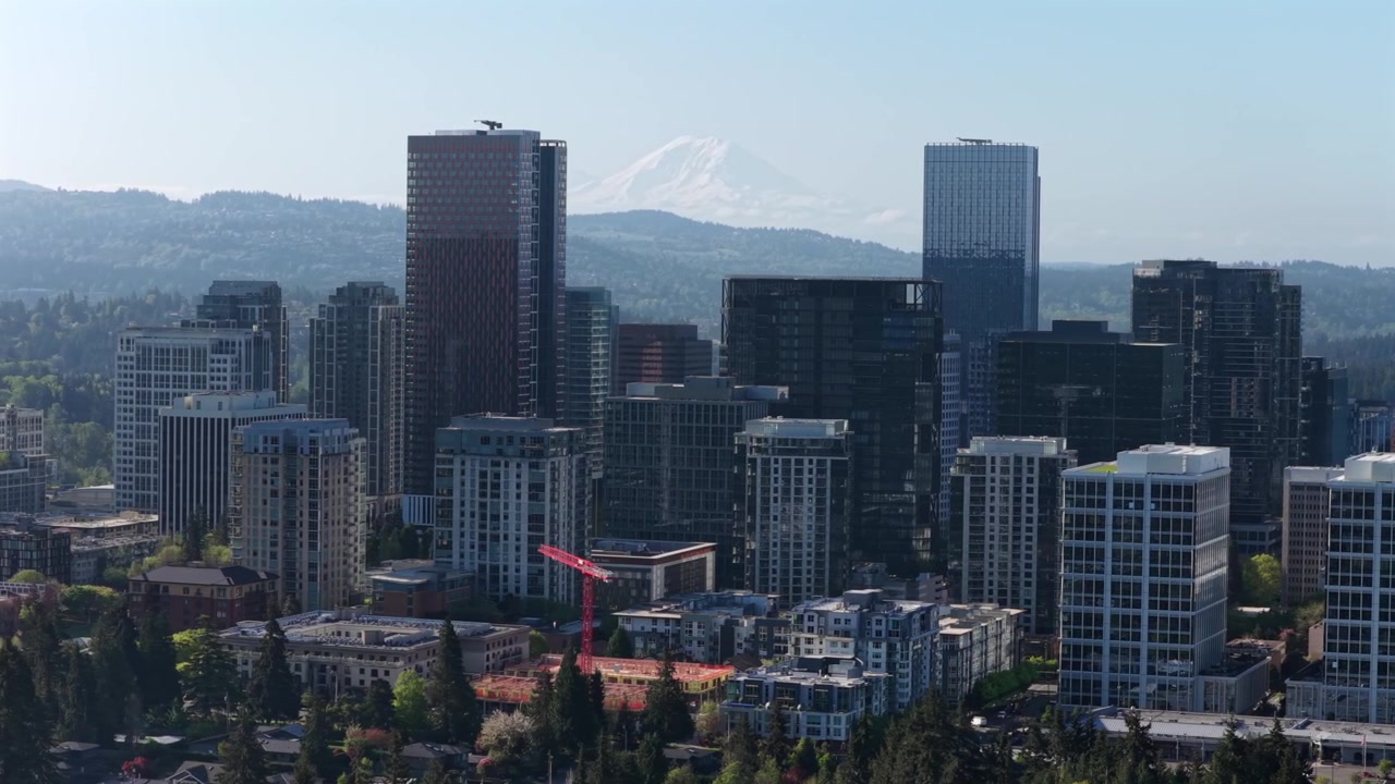 Skyline moderno di Bellevue, Washington, con lussuosi grattacieli, gru da costruzione e sviluppo urbano sotto la luce chiara del sole, paesaggio urbano del Pacifico nord-occidentale vicino a Seattle, Stati Uniti. Vista aerea.