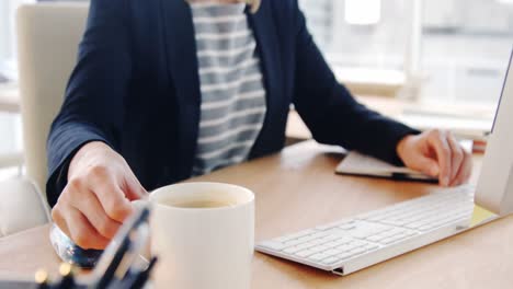 Geschäftsfrau-Trinkt-Kaffee,-Während-Sie-Am-Computer-Arbeitet