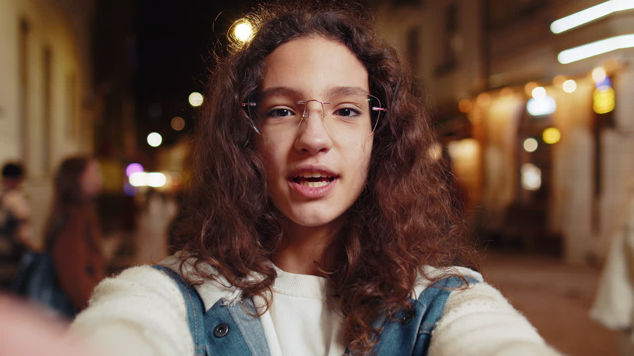 소녀 블로거가 스마트폰을 사용하여 구독자들과 온라인으로 비디오 통화를 통신하는 것을 볼 수 있습니다.