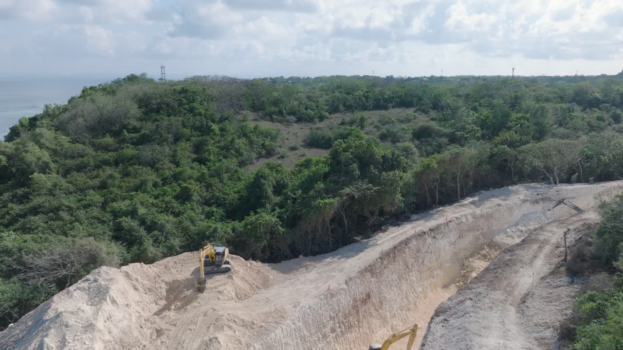video de avión no tripulado volando bajo sobre la destrucción ambiental de los acantilados de piedra caliza cerca del templo de pura luhur uluwatu, bali, indonesia, con excavadoras, limpieza masiva de la tierra y océano contaminado