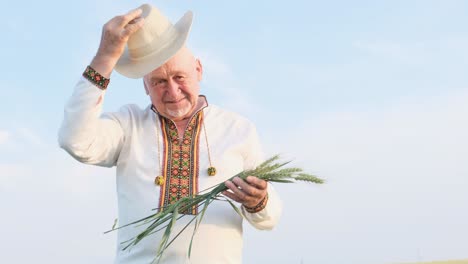 man in ethnic clothing with wheat and hat