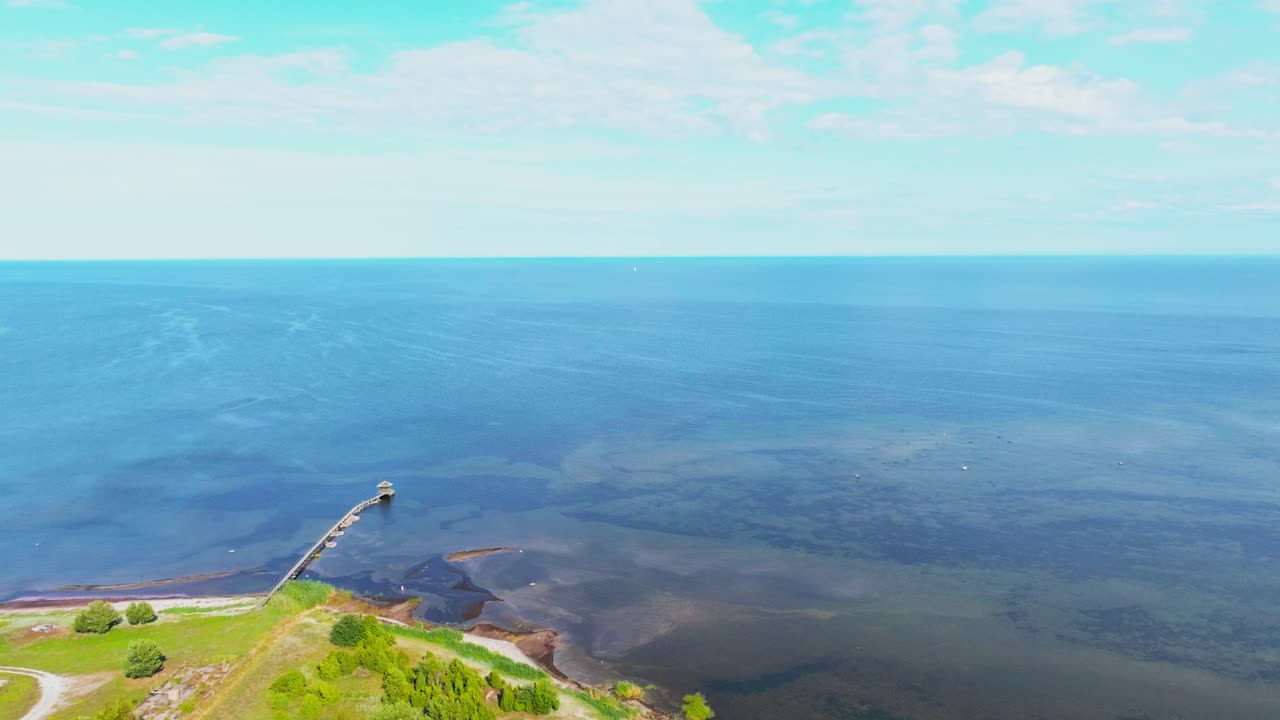 Flying high towards the sea, coastline and small harbor sauna visible