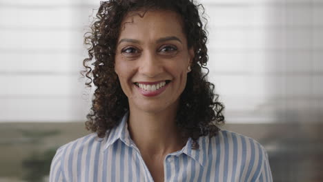 Retrato-De-Una-Hermosa-Mujer-De-Negocios-Hispana-Madura-Sonriendo-Mirando-La-Cámara-Feliz-Disfrutando-De-Una-Carrera-Exitosa-En-El-Fondo-Del-Espacio-De-Trabajo-De-Oficina