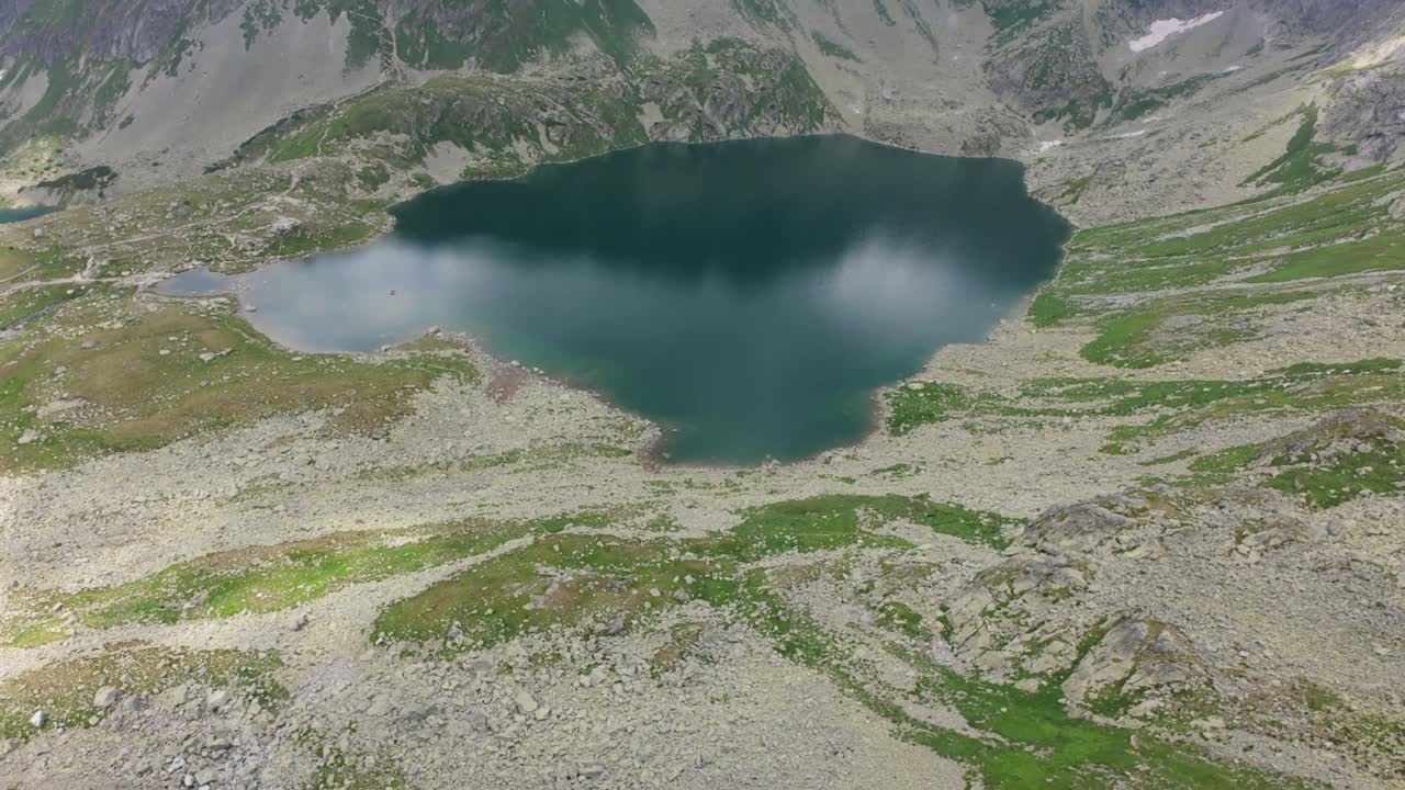 drone fpv volando sobre un tranquilo lago de montaña en los altos tatra de eslovaquia