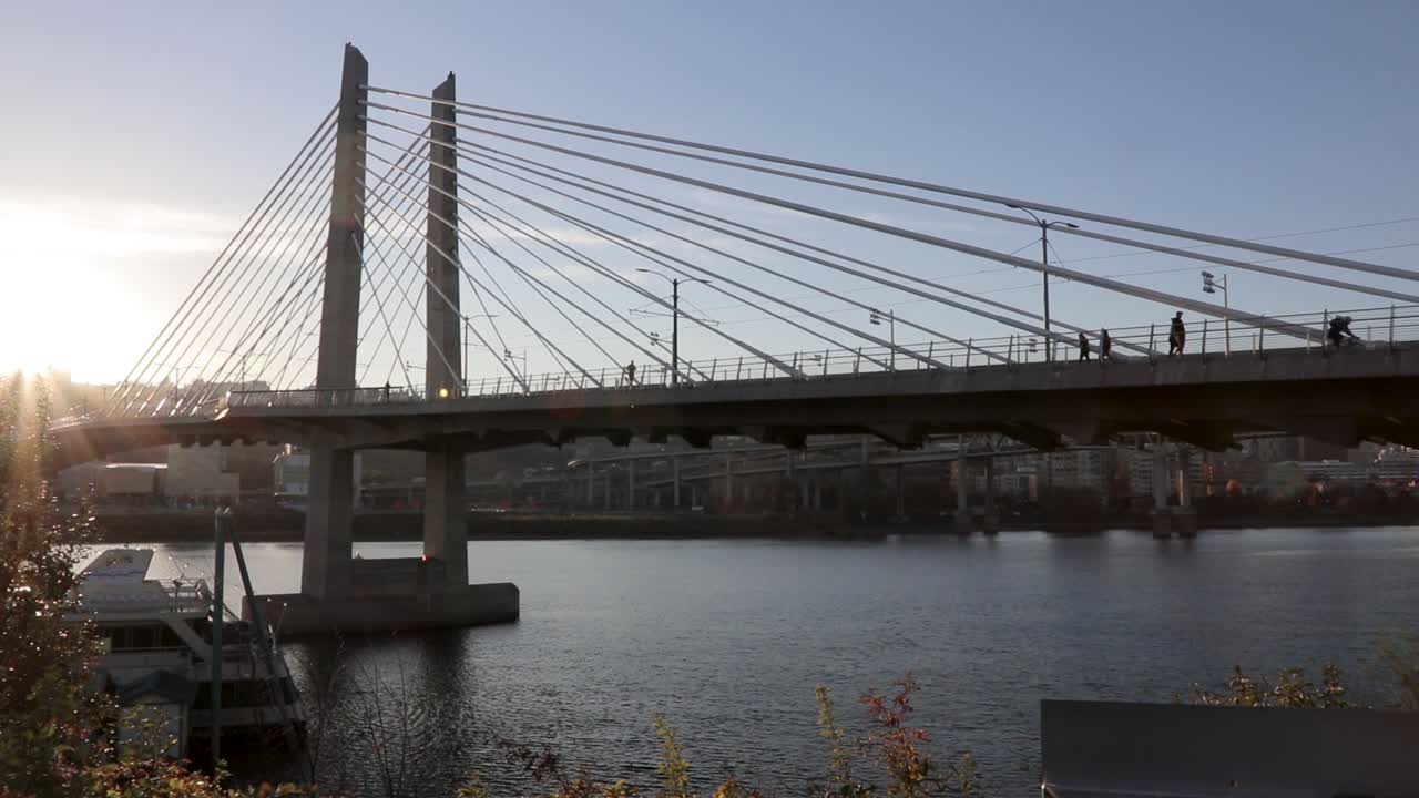 Slow pan showing people walking over the Tilikum pedestrian bridge in Portland, Oregon.