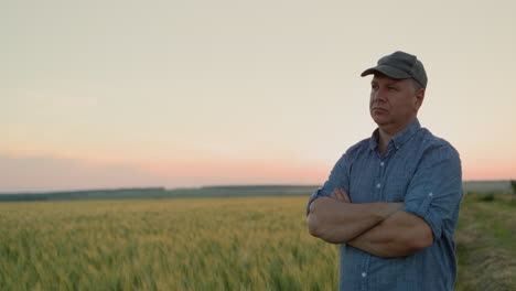 retrato de un agricultor de mediana edad frente a un campo de trigo