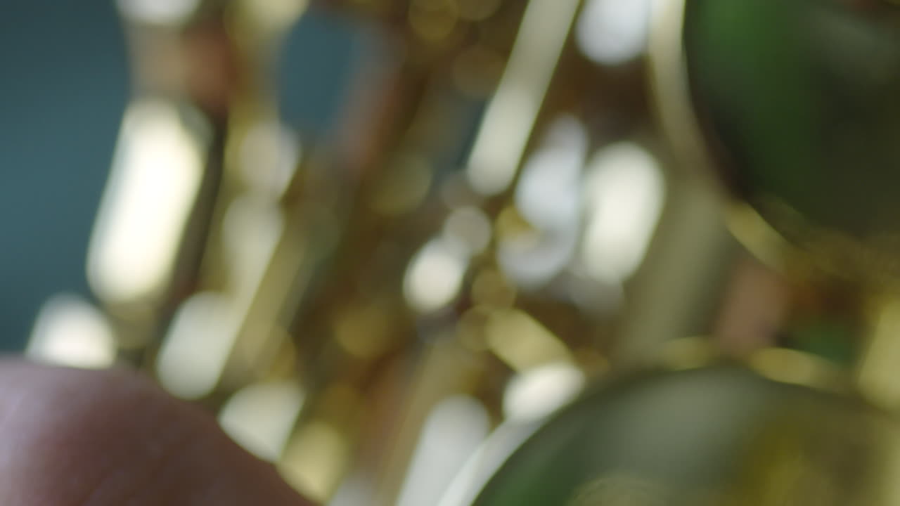 Close-up abstract of a hand playing a brass instrument