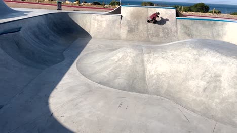 a skateboarder slides a skatepark bowl